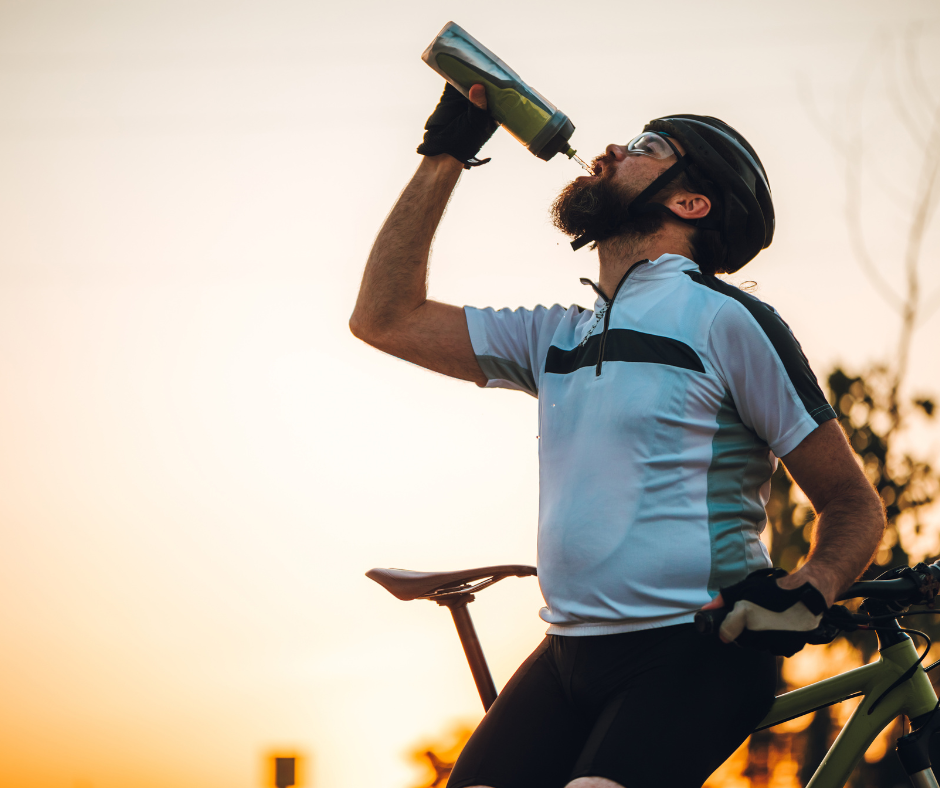 Ciclista bebiendo agua al final de una sesión de entrenamiento para mantener la hidratación y evitar la deshidratación.