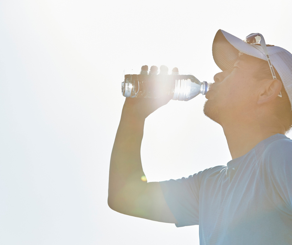 Corredor bebiendo agua durante el entrenamiento para prevenir la deshidratación deportiva.